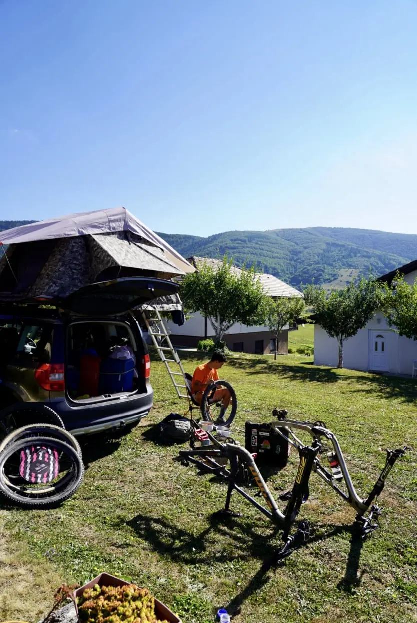 George Kouzis fixing his bike next to a Skoda Car